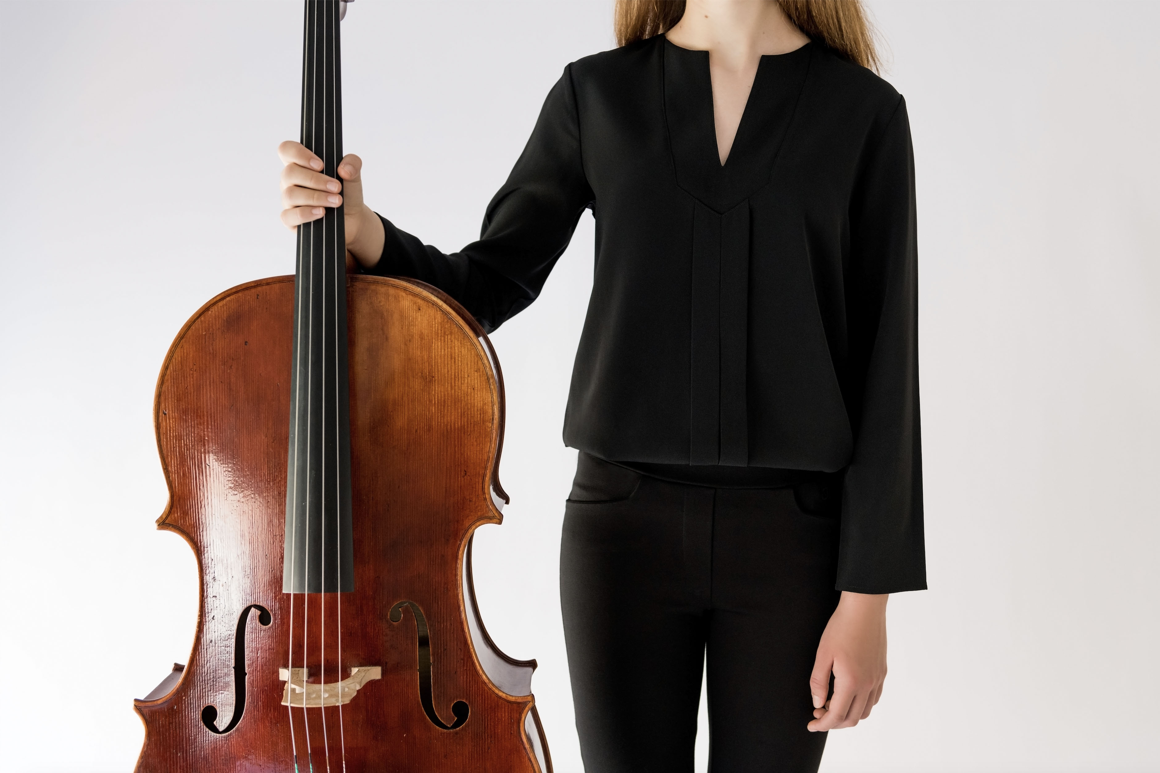 girl dressed in black holding a cello