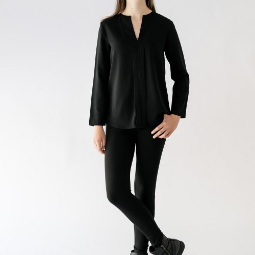 girl standing wearing black blouse and black pant
