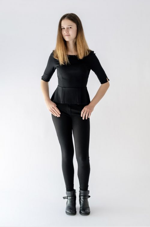 girl standing wearing black pant and peplum top