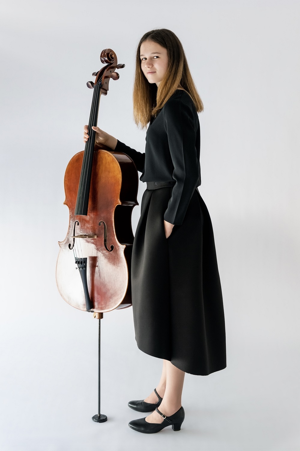 girl standing holding cello