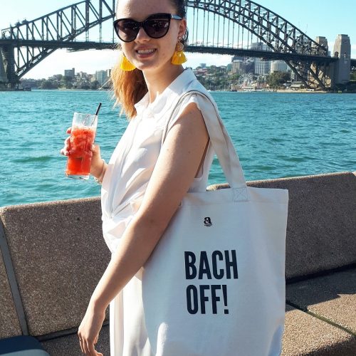 girl with bach off tote bag in front of sydney harbour bridge