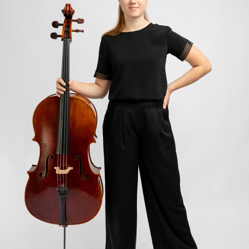 girl in black clothes holding cello